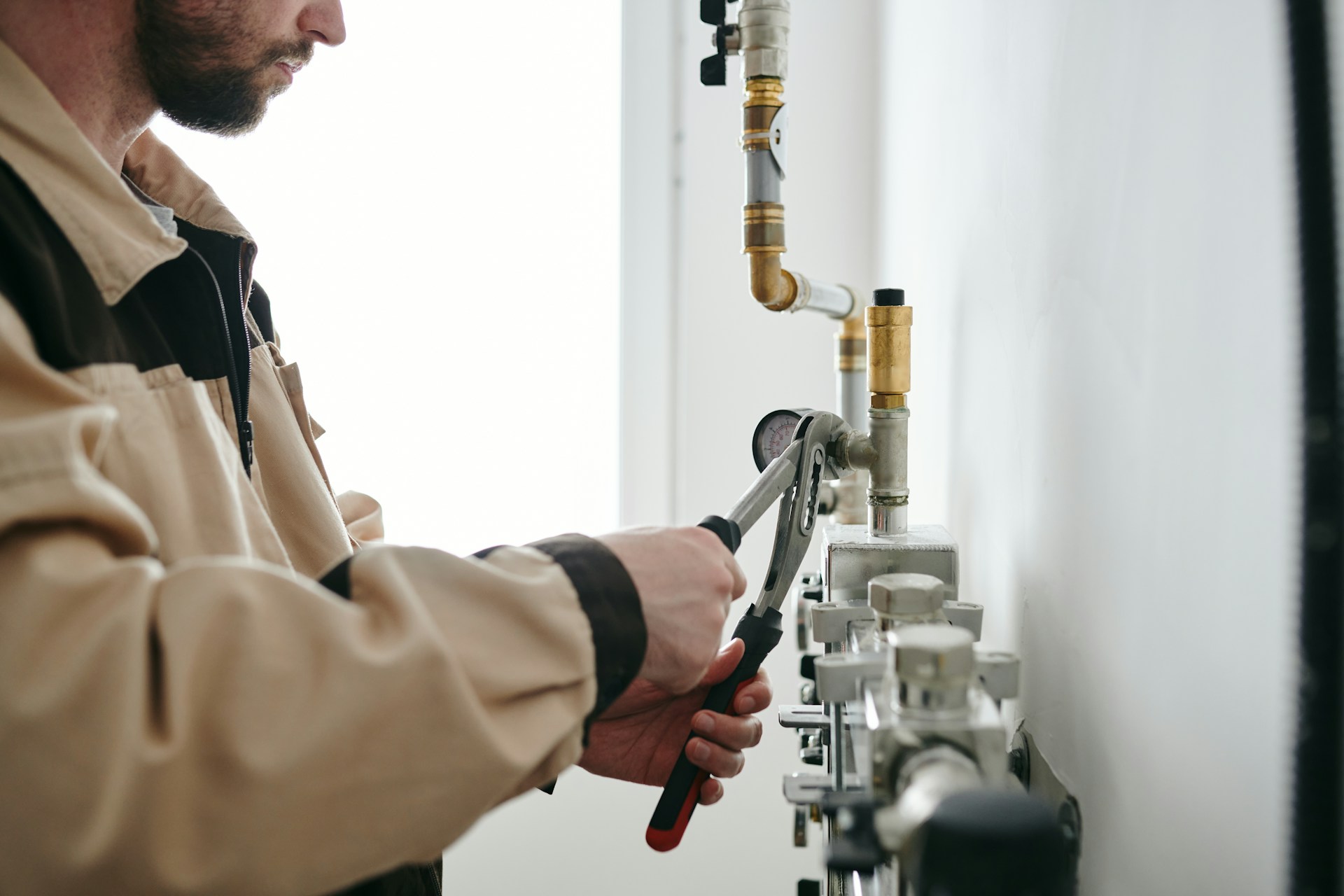 A plumber tightening bolts with a wrench