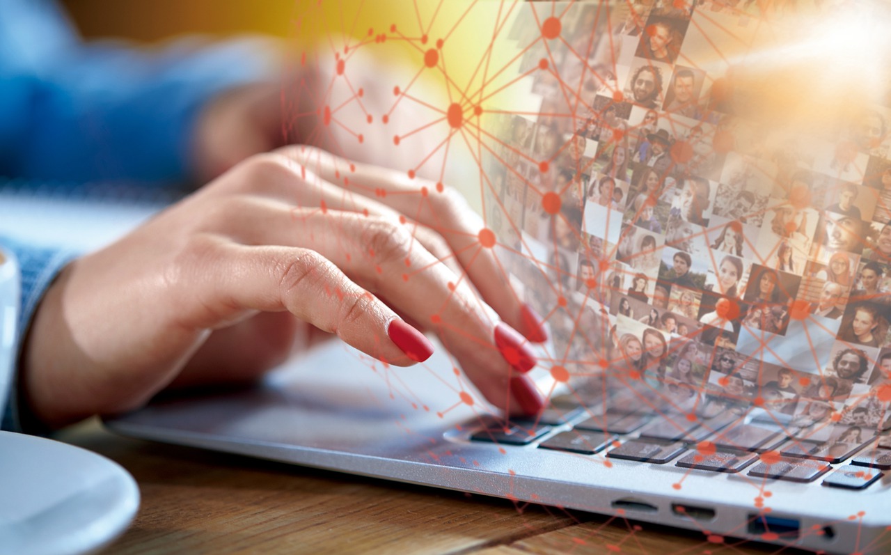 a woman using a laptop that has people's profiles floating out of the screen