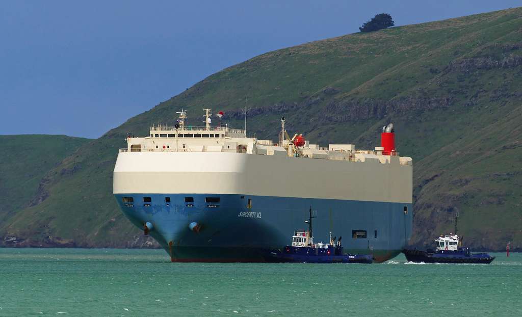 a car carrier vessel and tugboats