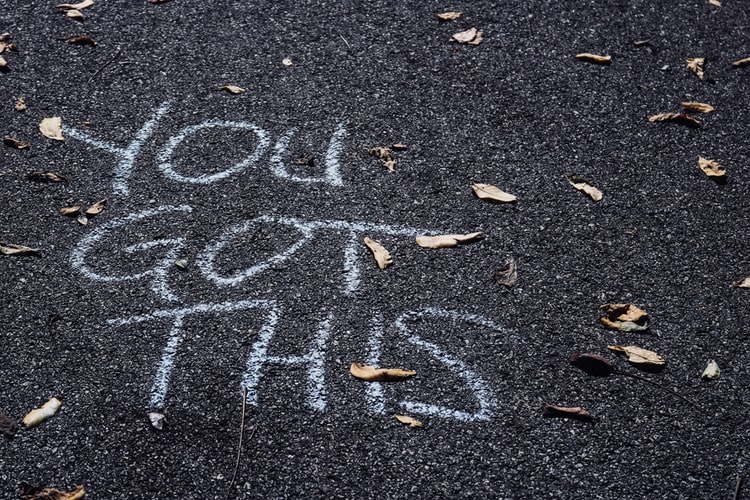 The words 'you got this' written in chalk on tarmac 