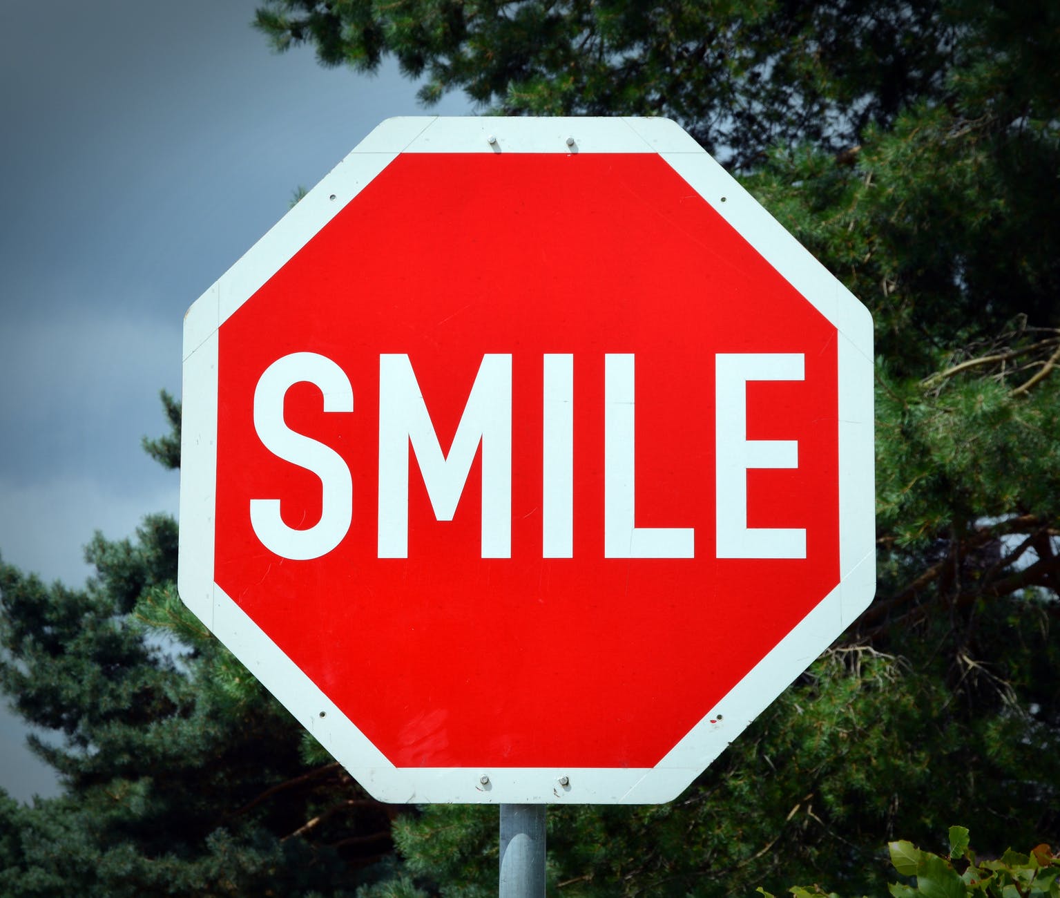 A red traffic stop sign with the word 'smile' on it