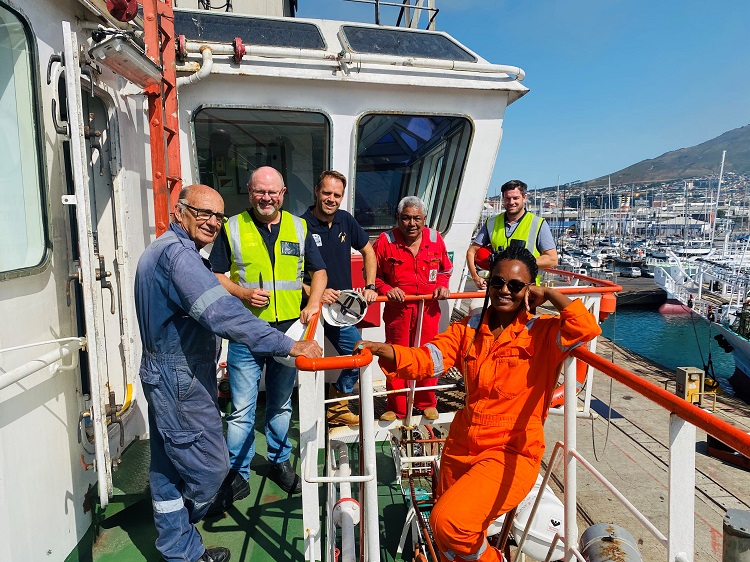 A smiling crew working in seafarer jobs on a small commercial vessel 