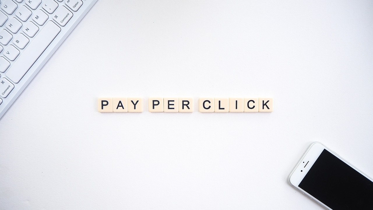 a keyboard and phone and tiles spelling out 'pay per click' 