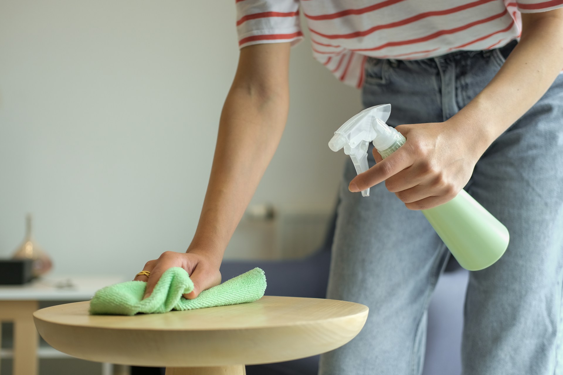 a person polishing a table with spray