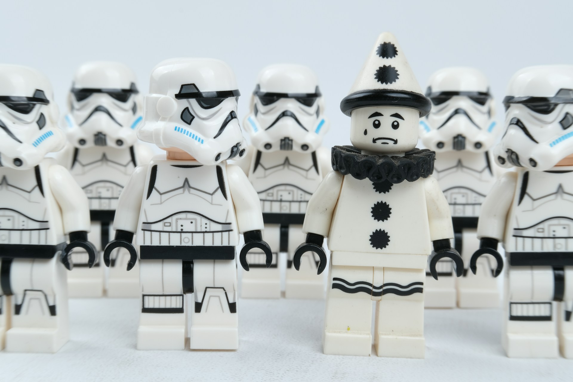A group of Lego Stormtroopers and one solo Lego Pierrot clown in the middle