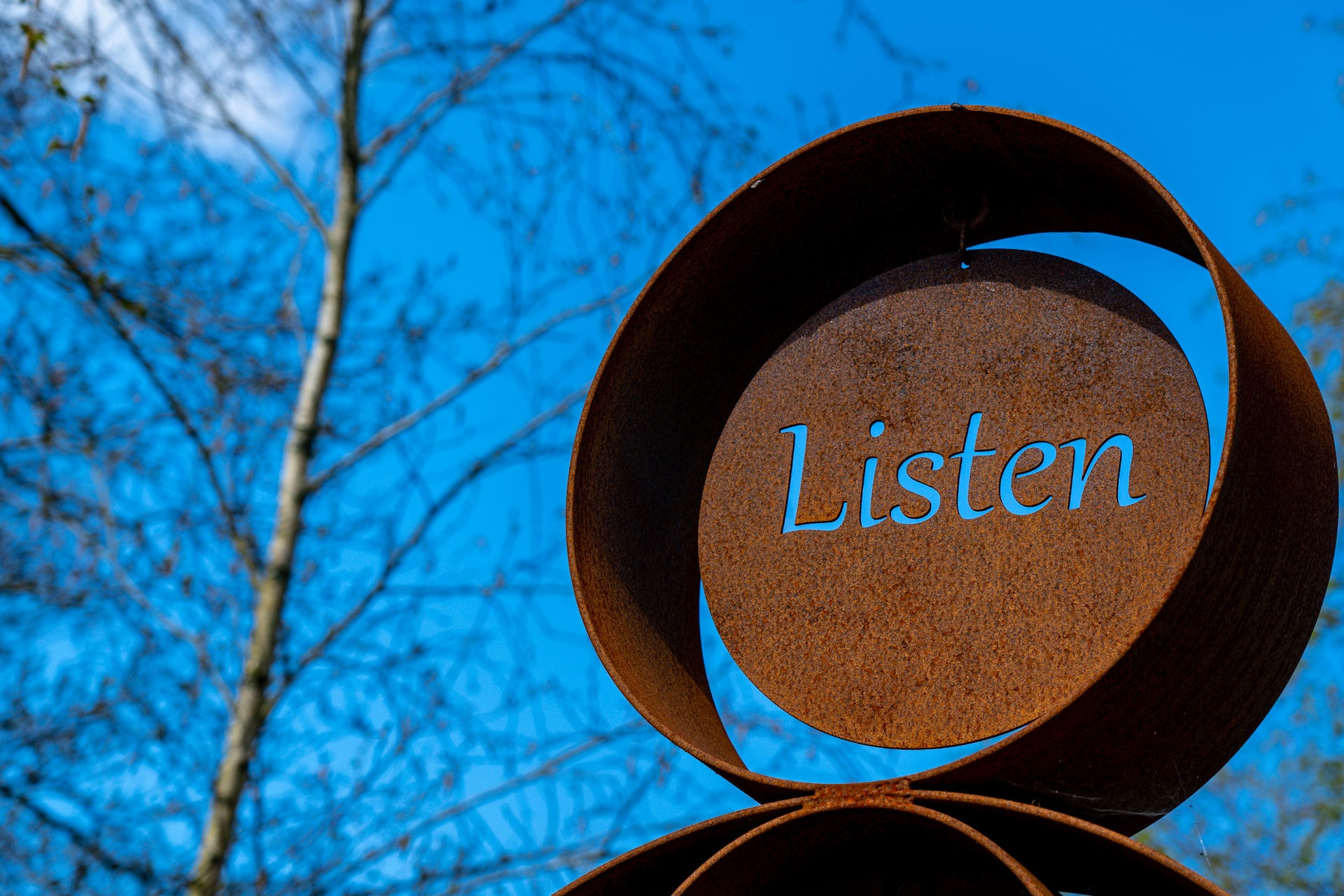 A street sculpture with the word 'listen' cut out of it