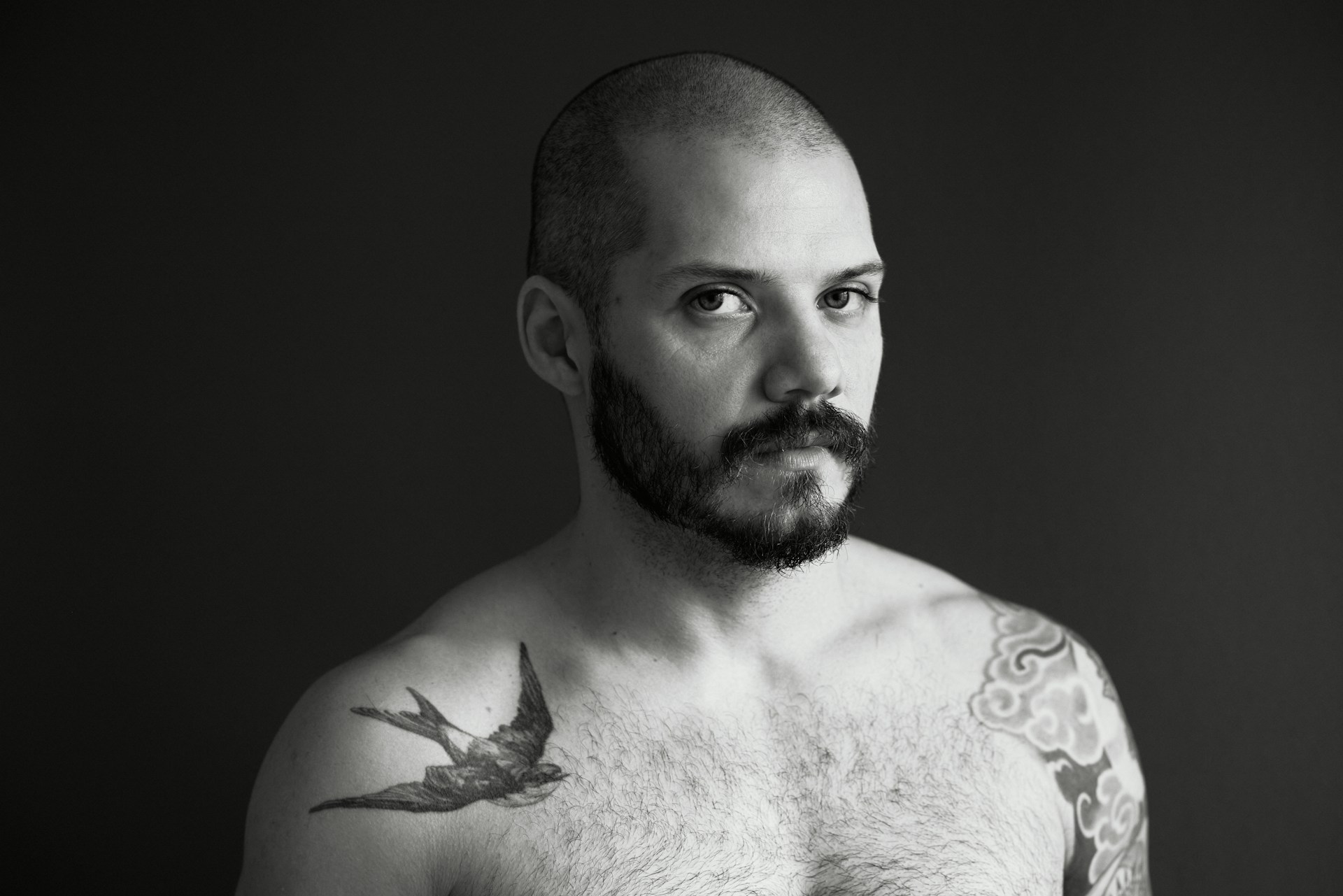 a man with a swallow tattoo on his shoulder 