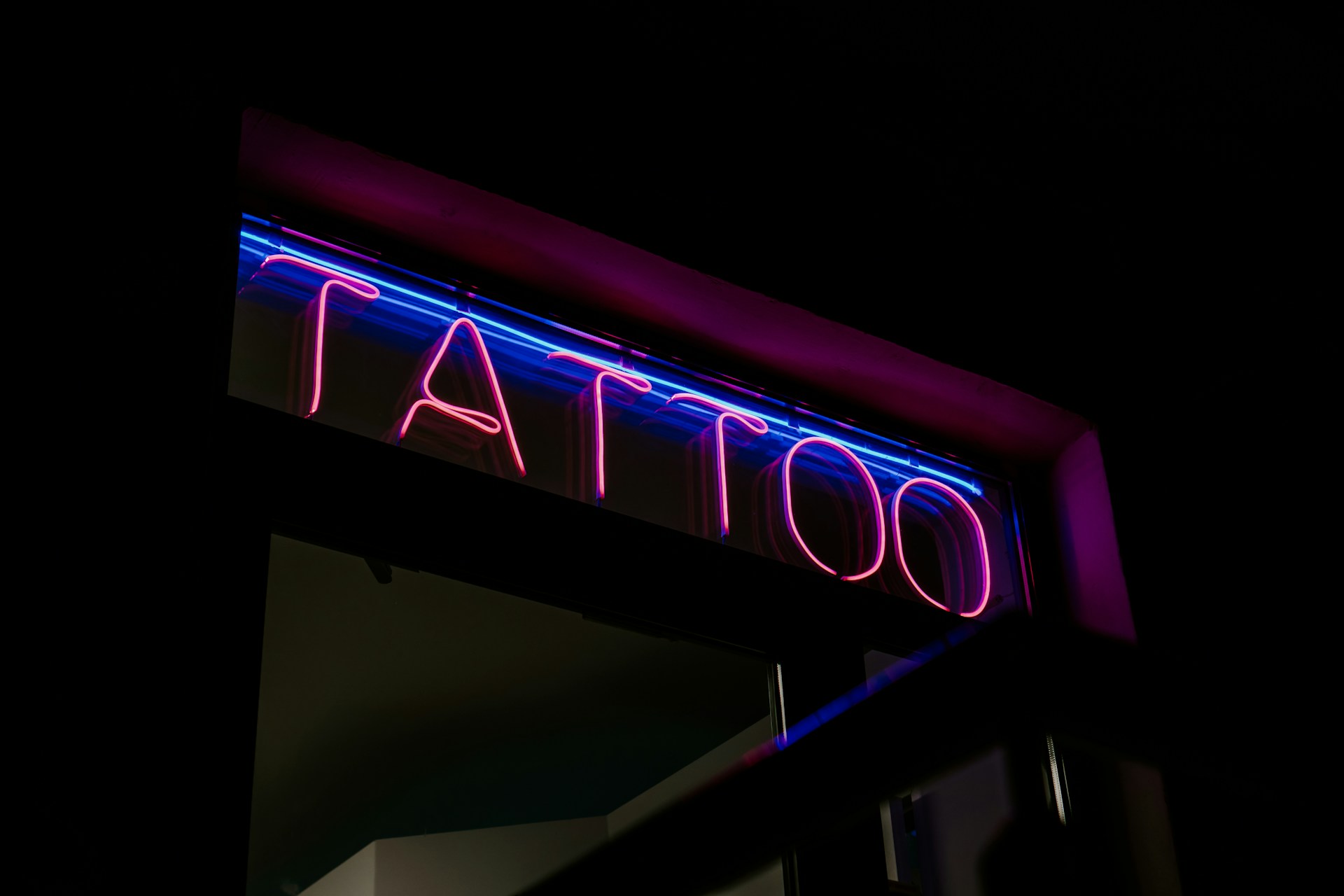 a neon sign saying 'tattoo'