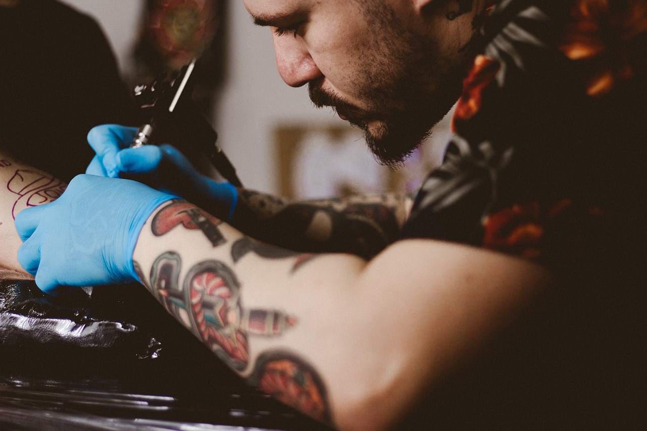 a tattoo artist tattooing a customer