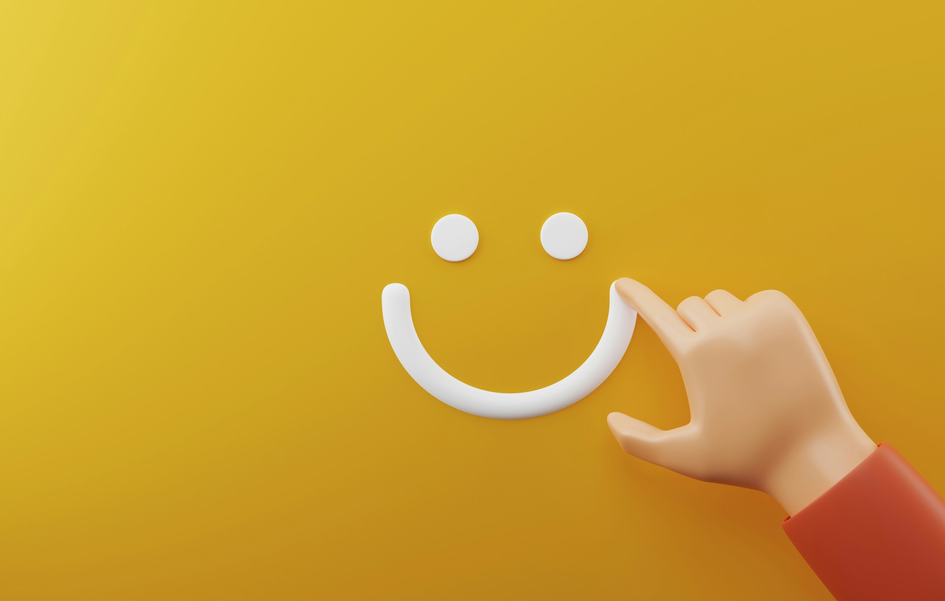 a hand drawing a smiley face on a yellow background