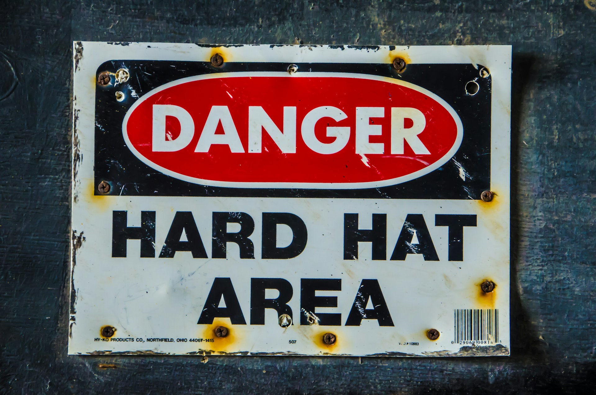 Tin sign saying 'danger hard hat area'