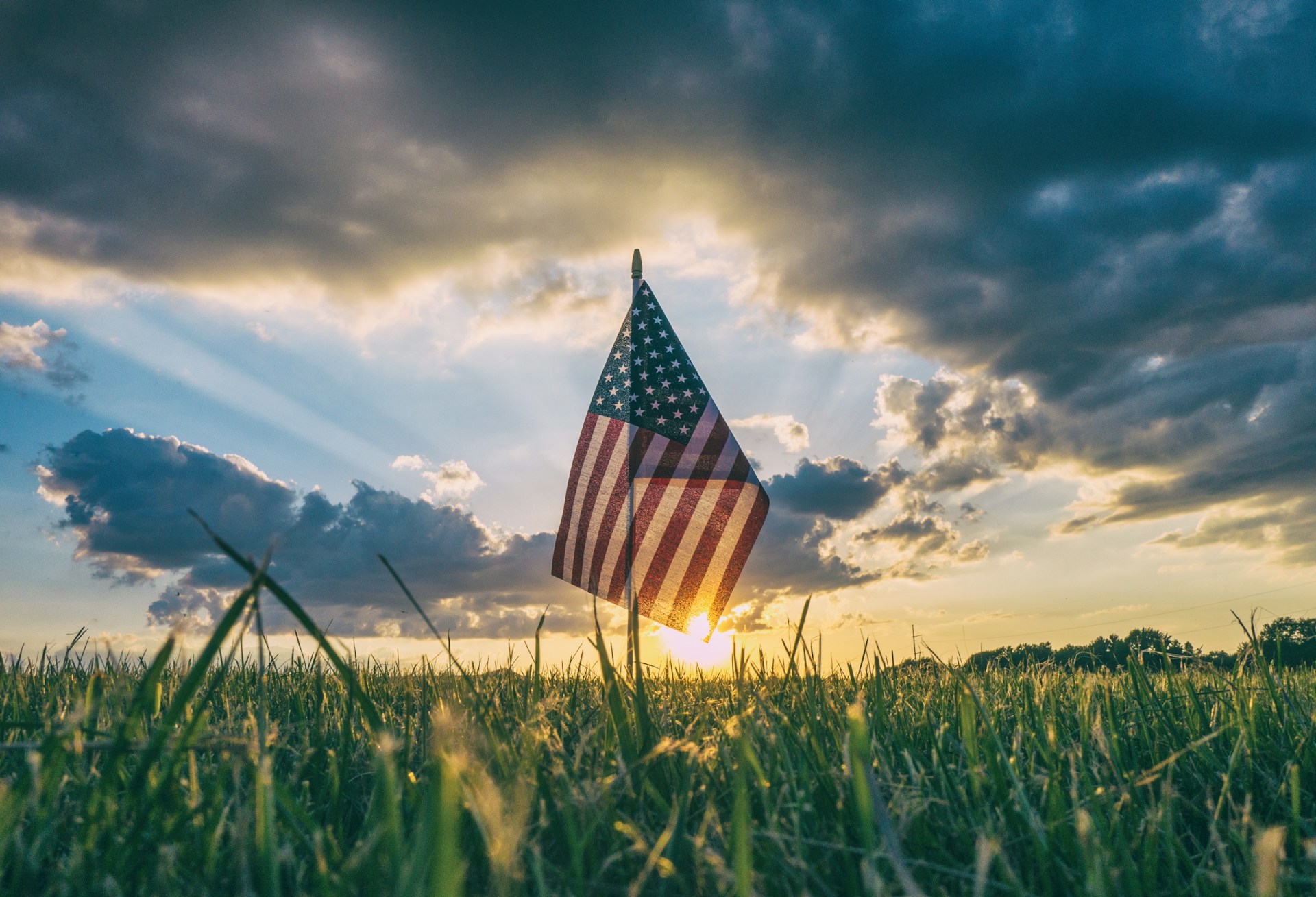 the Stars and Stripes in a field at sundown