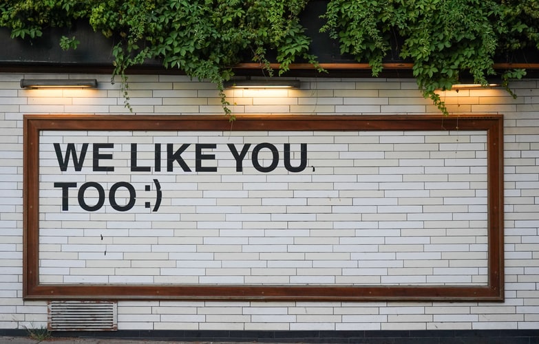 Lettering on a tiled wall saying 'we like you too'