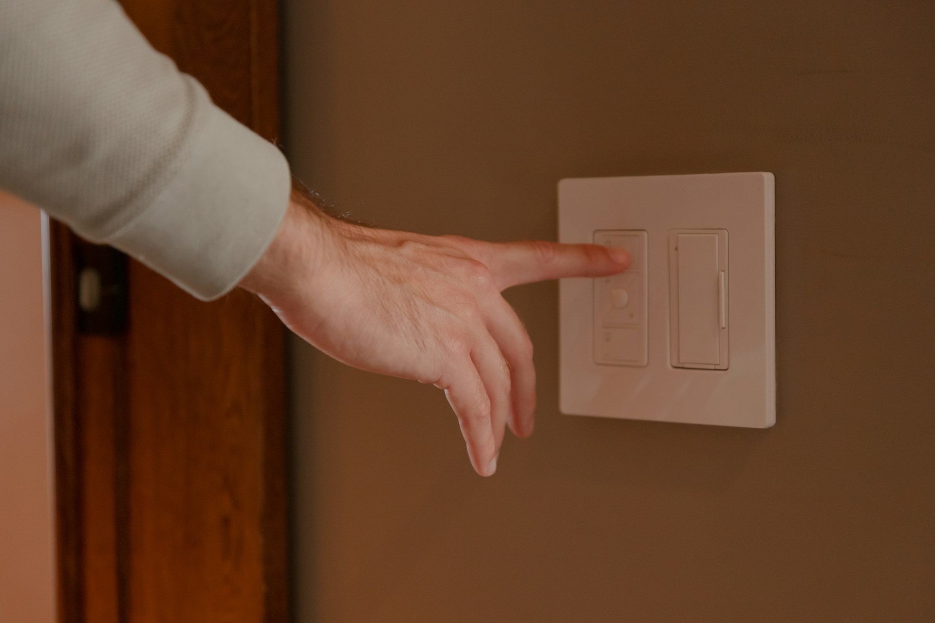 a man's finger pressing a light switch