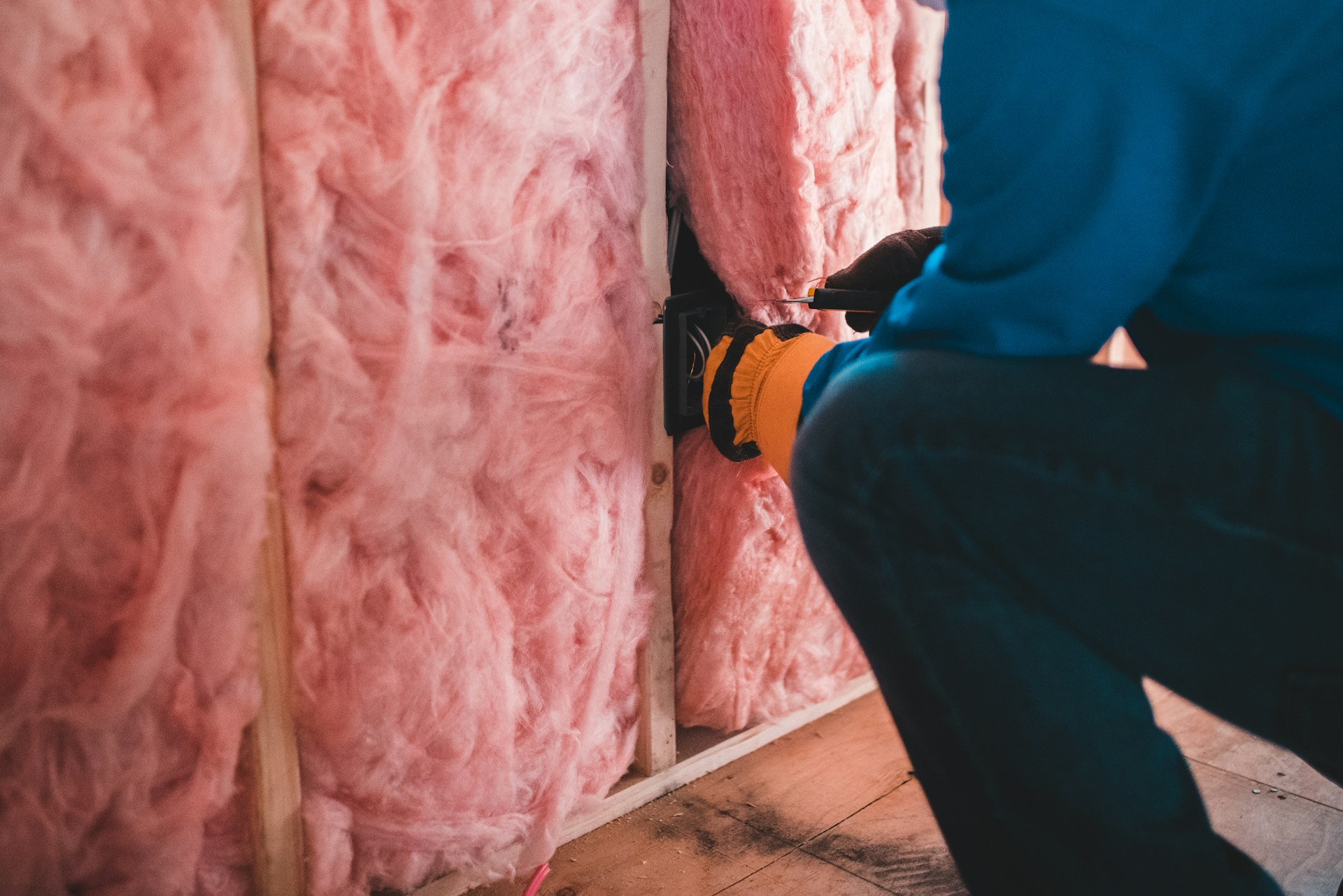 a person installing insulation into a building