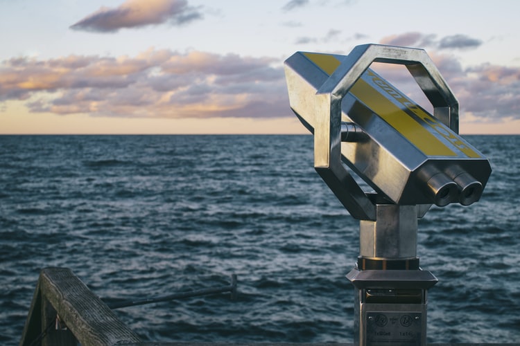 a telescope pointing towards the ocean
