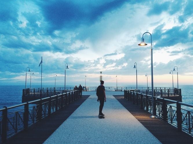man walking down pier