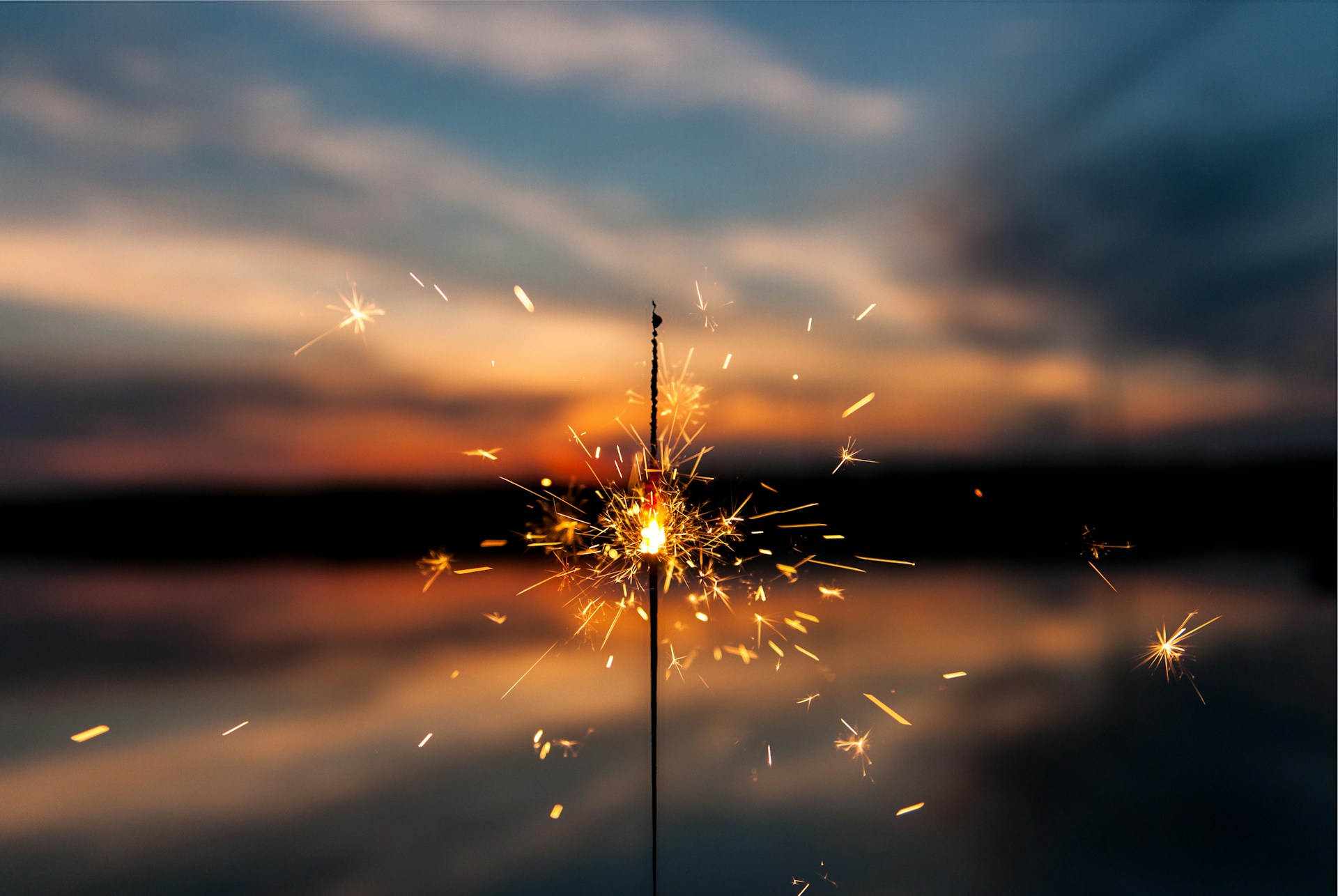 a sparkler in front of the ocean