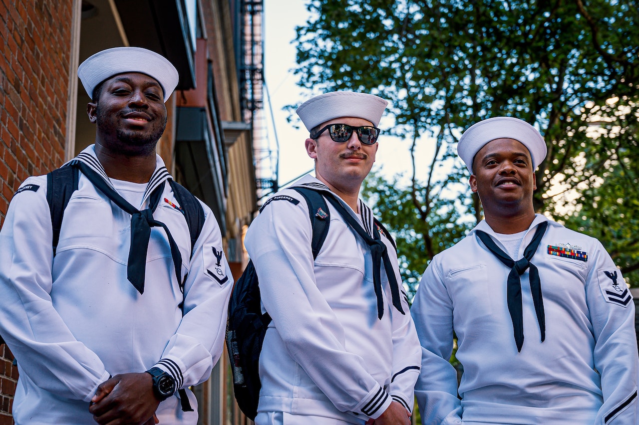 3 smiling sailors on shore leave posing for a photo together