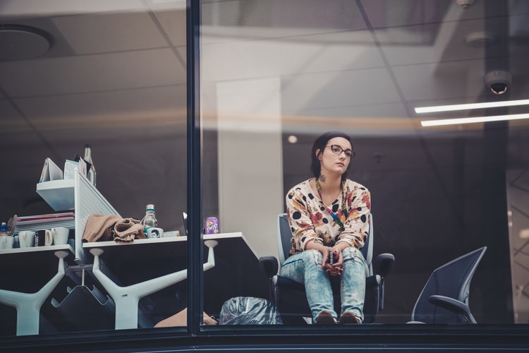 bored woman staring out of office window