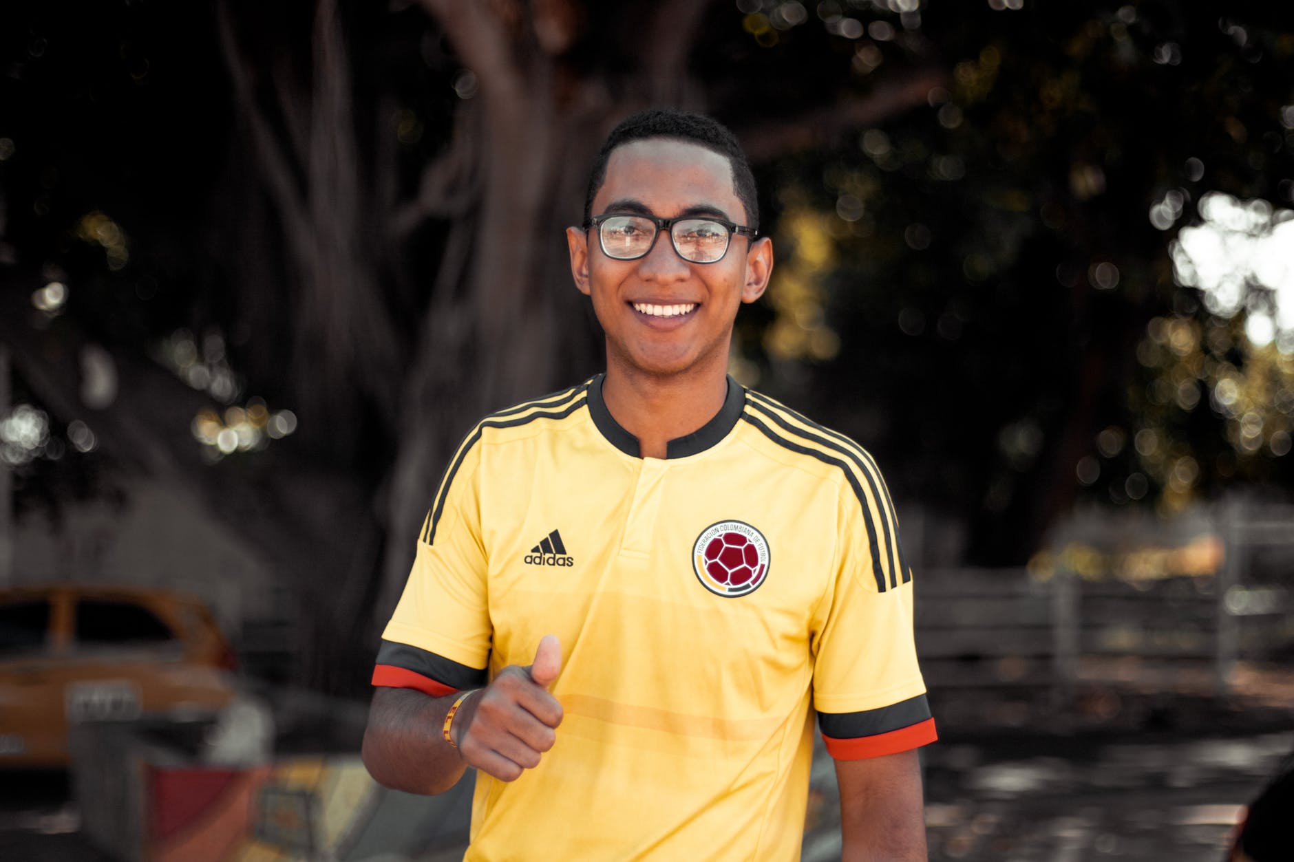 Smiling man in soccer shirt giving a thumbs up sign