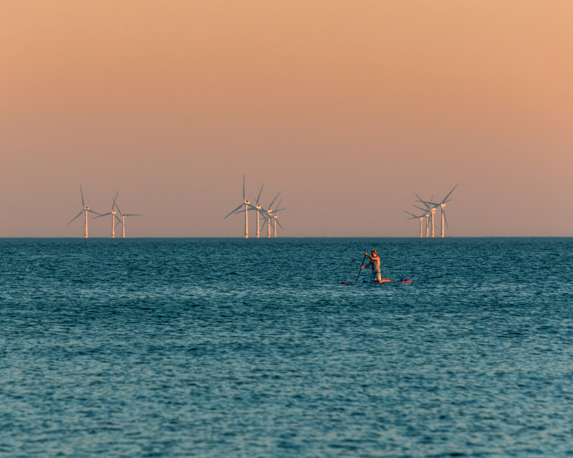 an offshore windfarm at sunset