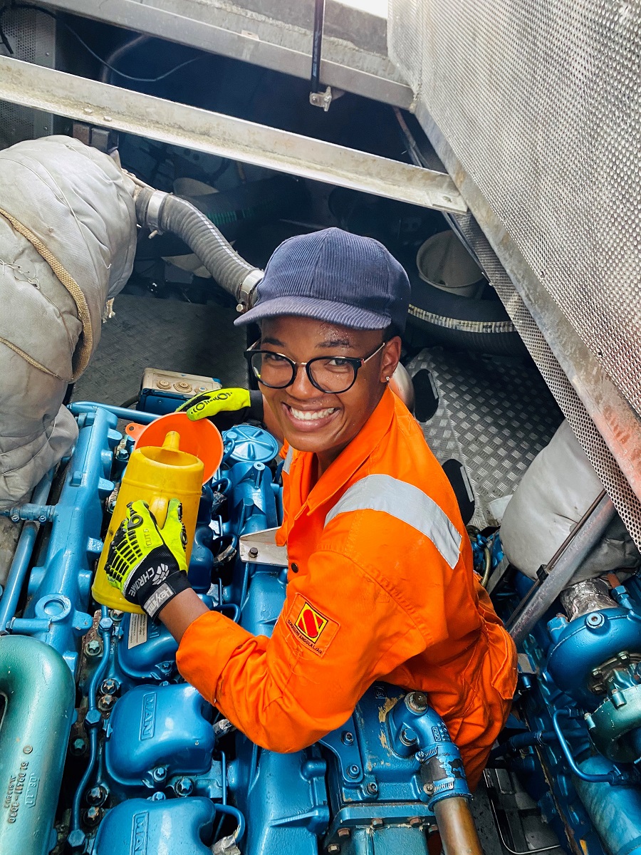 smiling woman working in an engineer job on a ship