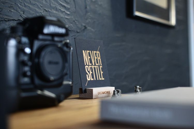 sign on desk saying never settle