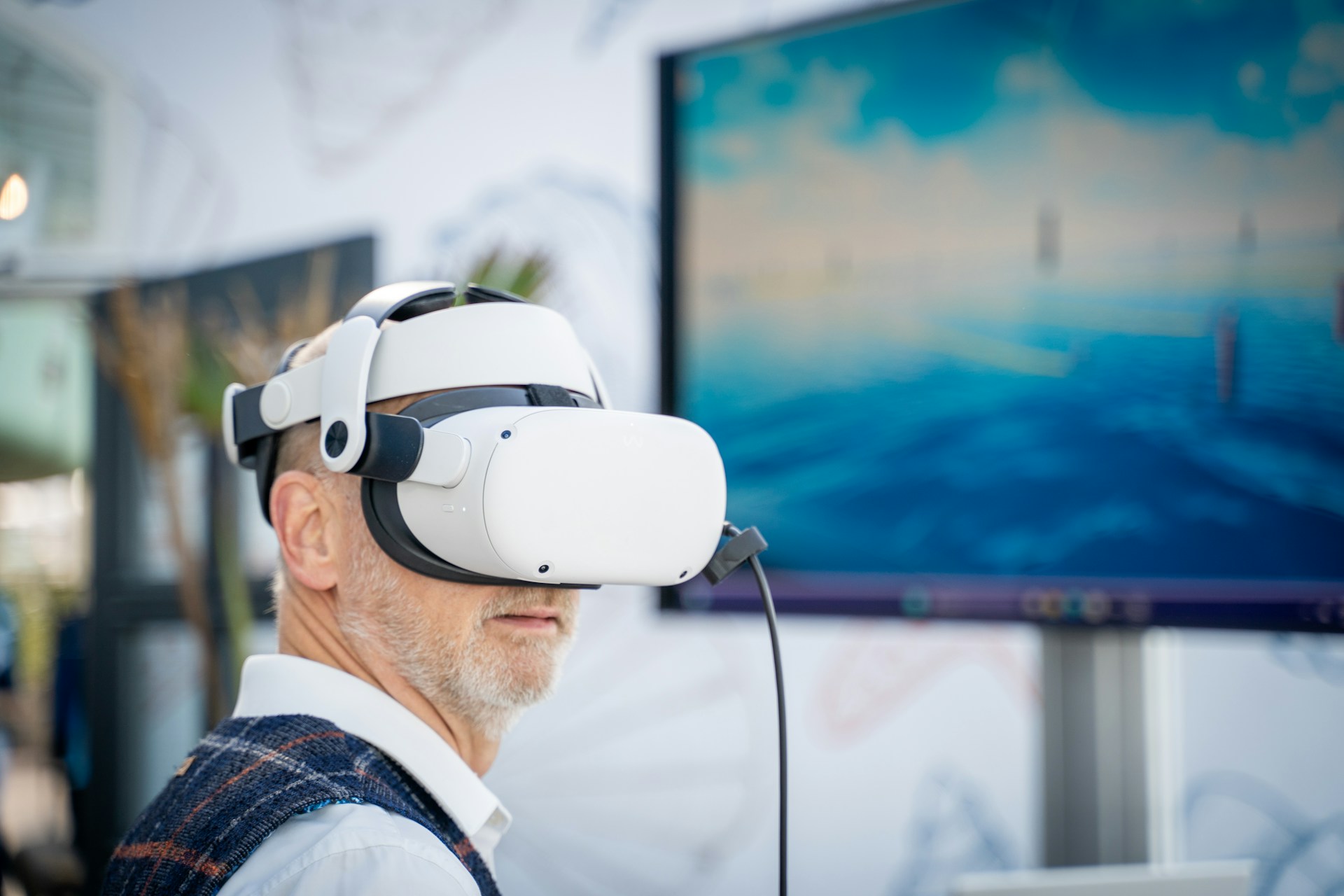 a man wearing a VR headset in front of a blue screen