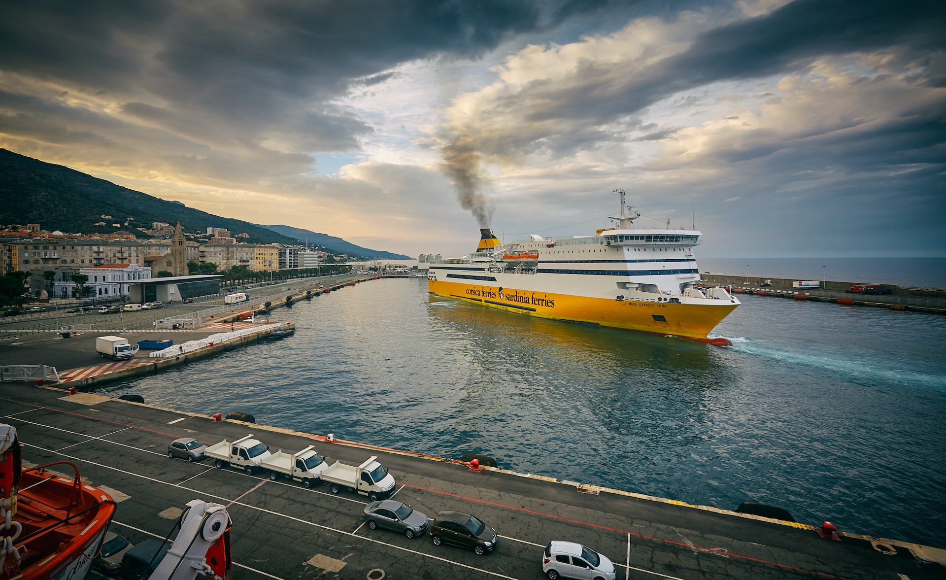 A yellow and white ferry sailing out of a port