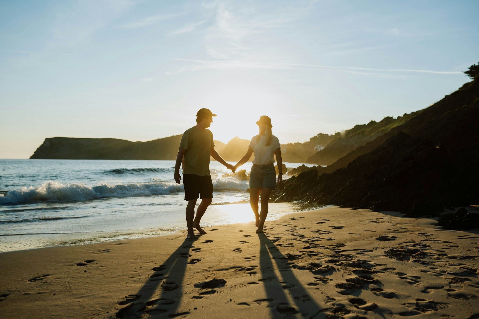 a couple holding hands on a beach