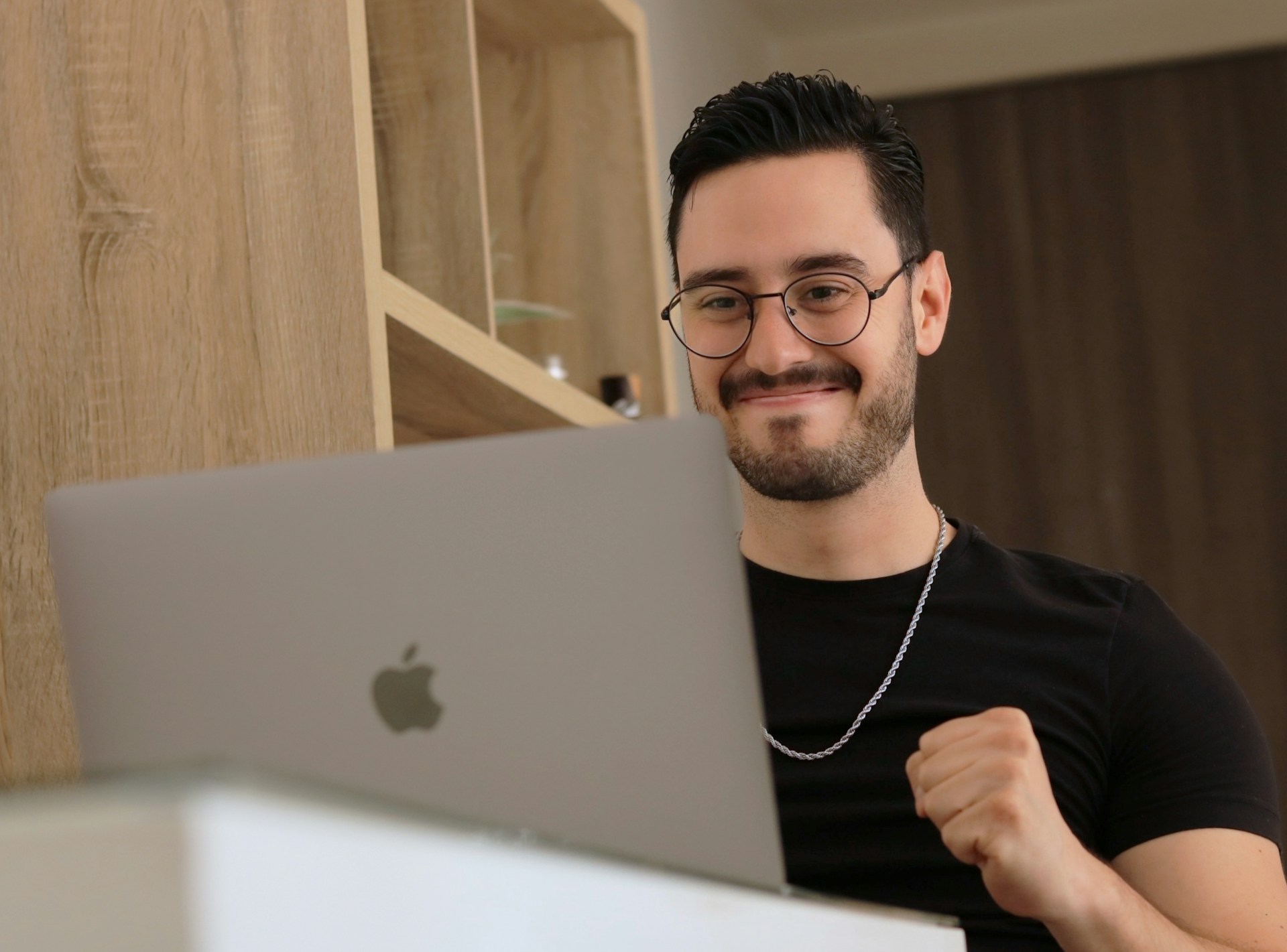 A pleased looking man smiling at his laptop