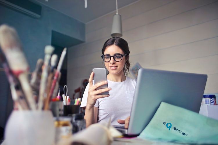 woman using phone and laptop