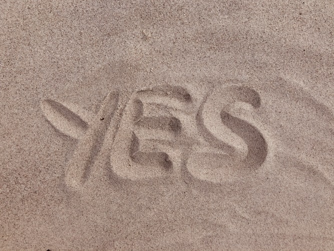 The word 'yes' written in sand