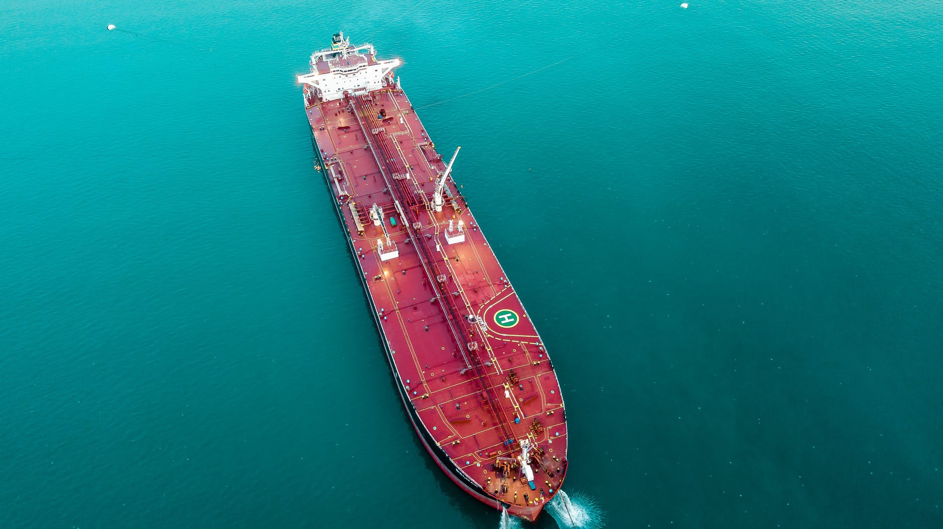 aerial view of a red oil tanker on a turquoise sea