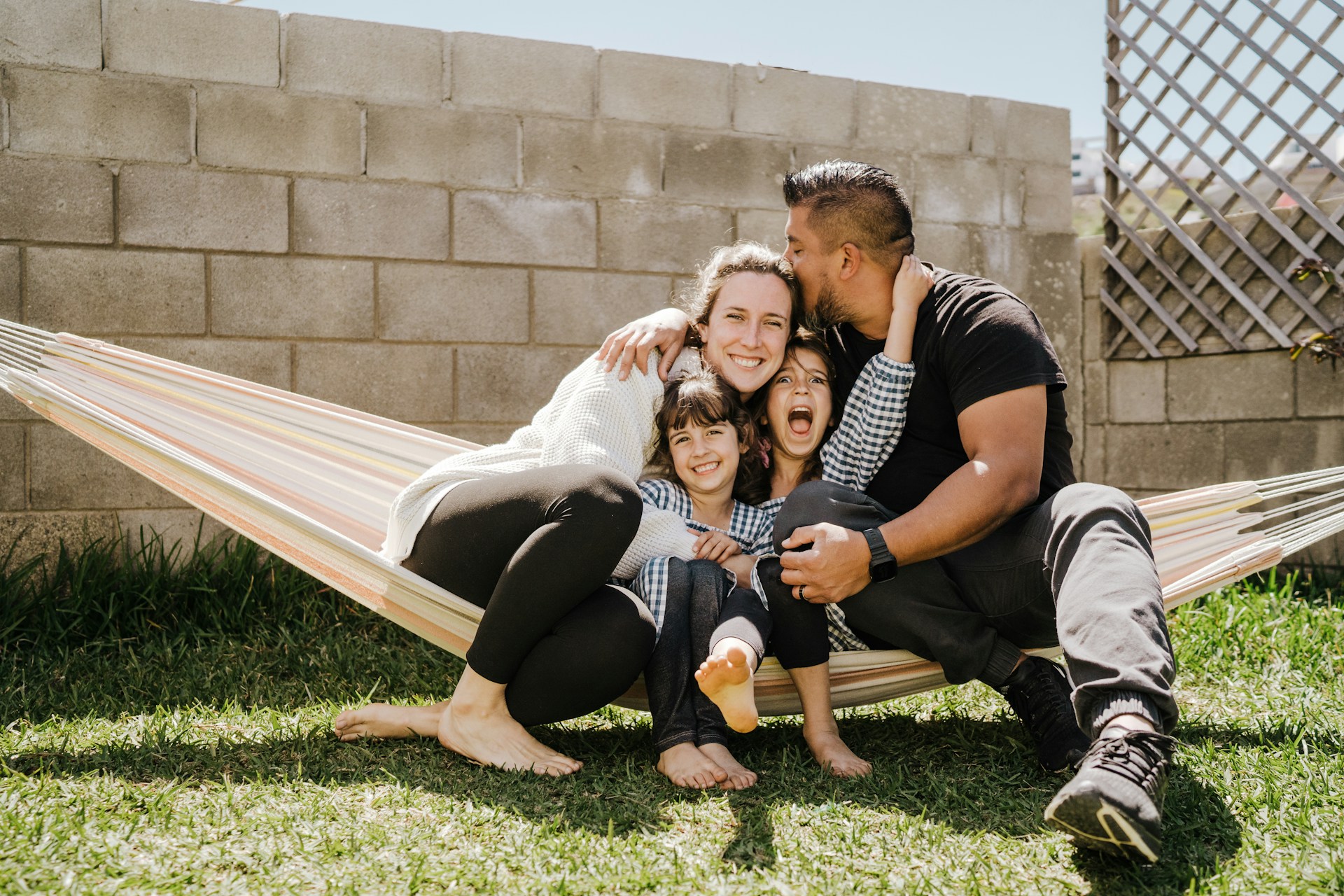 parents and two kids sitting on a hammock