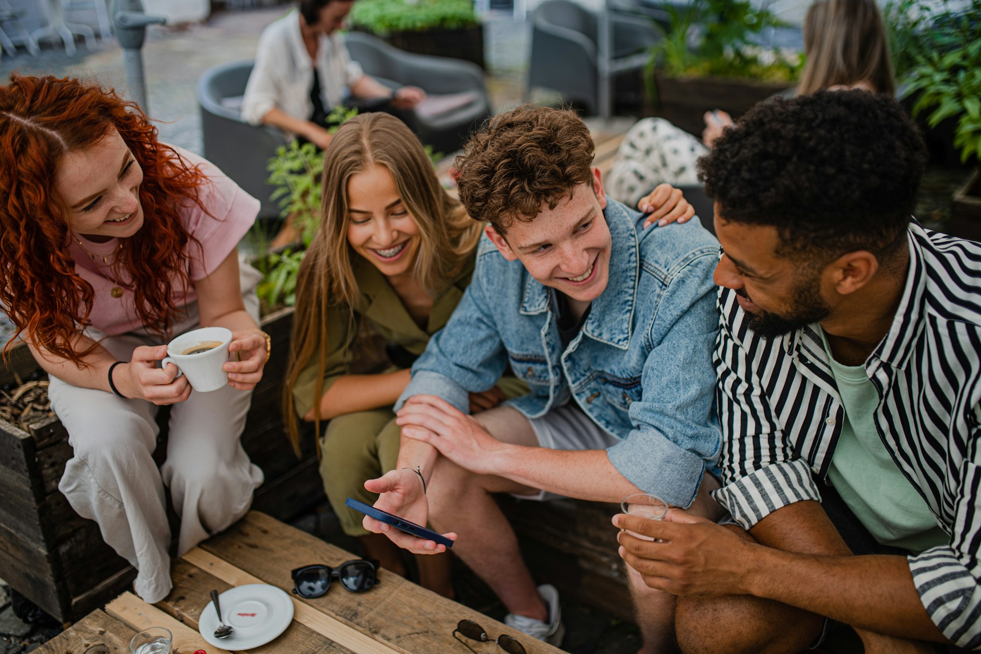 four friends drinking coffee in a cafe