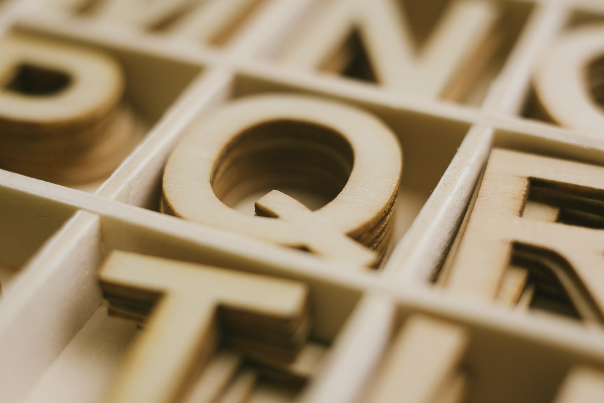 Wooden letters in a box including Q and R