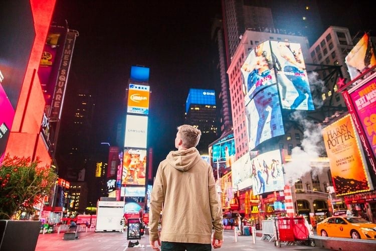 man looking at neon adverts