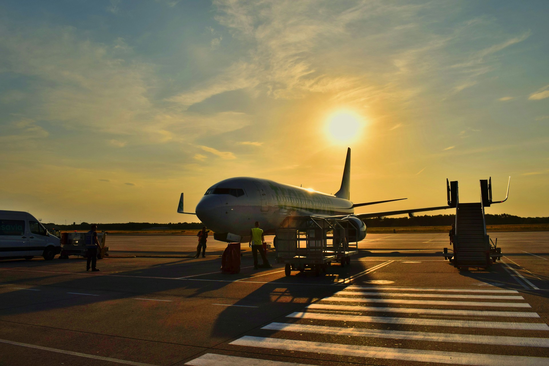 an airplane on the tarmac at sunset