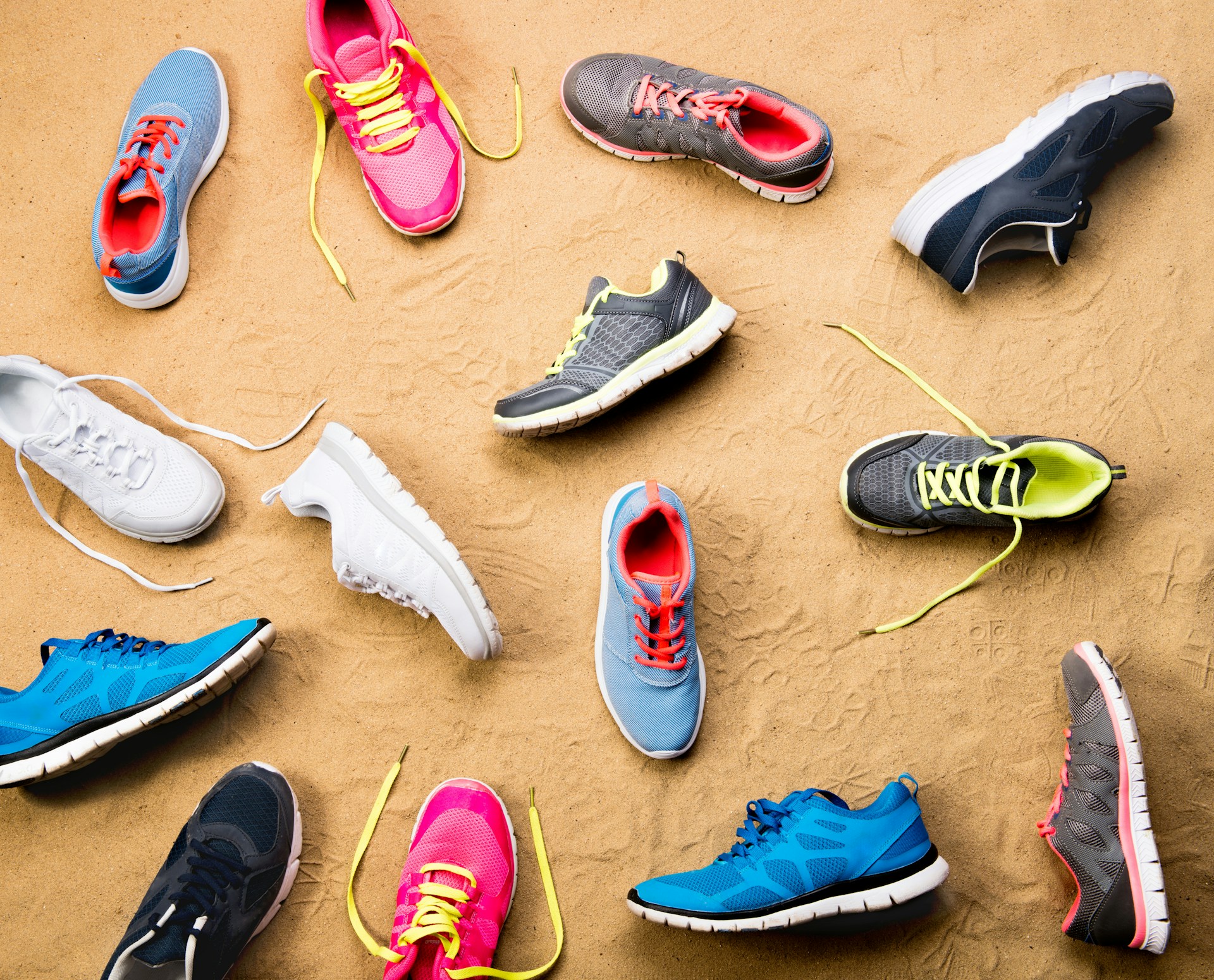 brightly colored assorted sneakers on sand