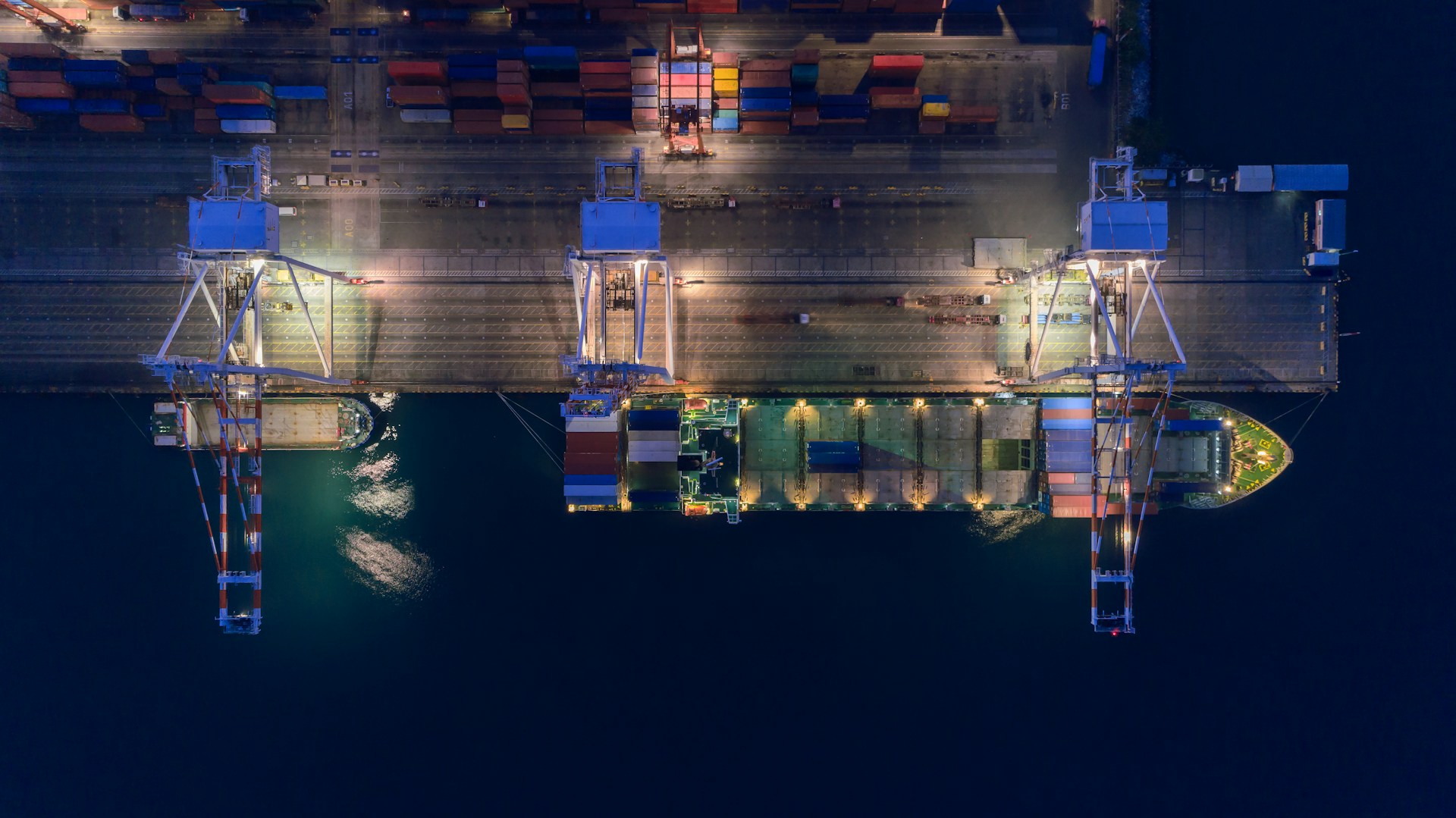 an aerial view of a cargo ship in port at night