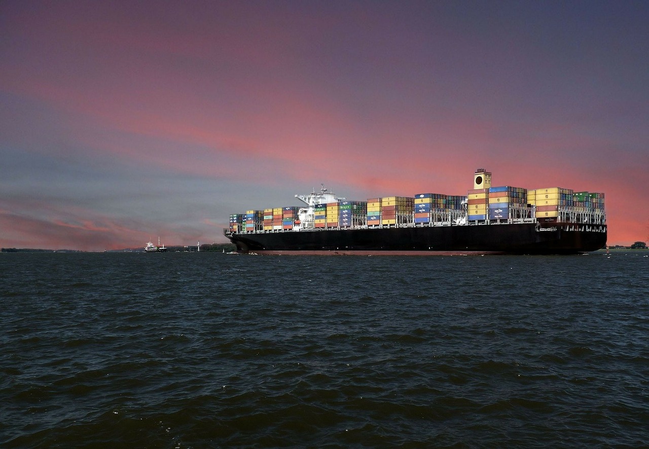 a container ship under a pink and grey sky