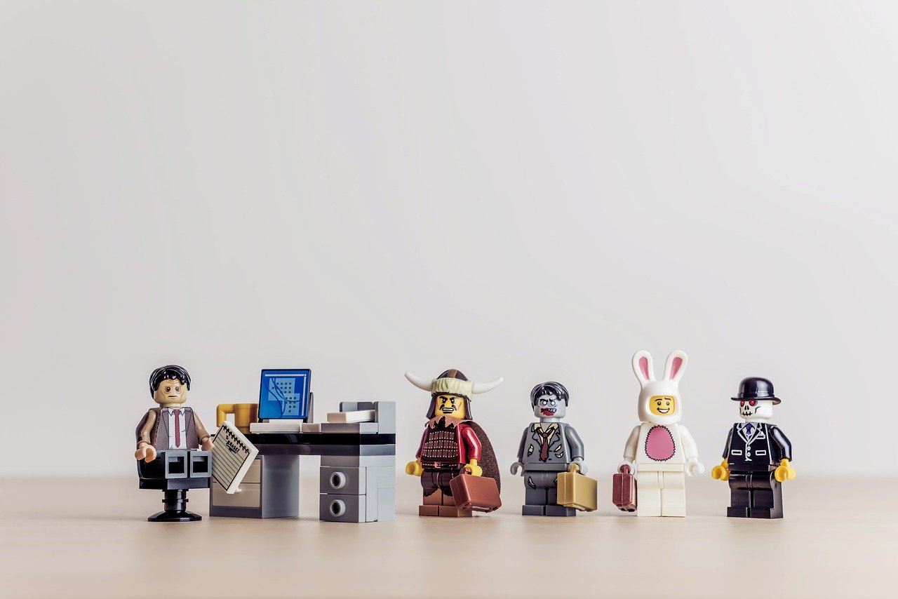 Lego figures lining up at a desk in an office