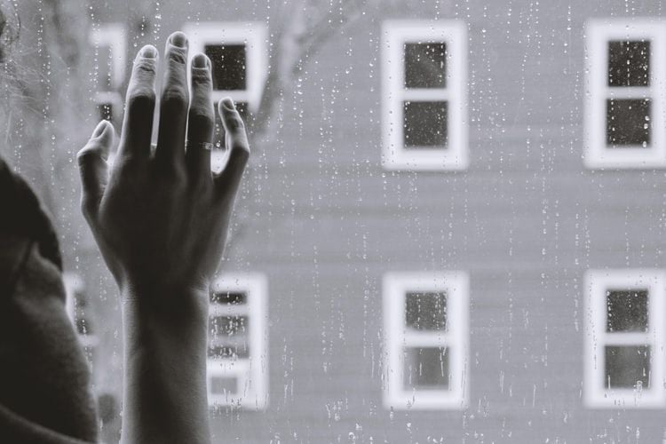 hand in front of rainy window