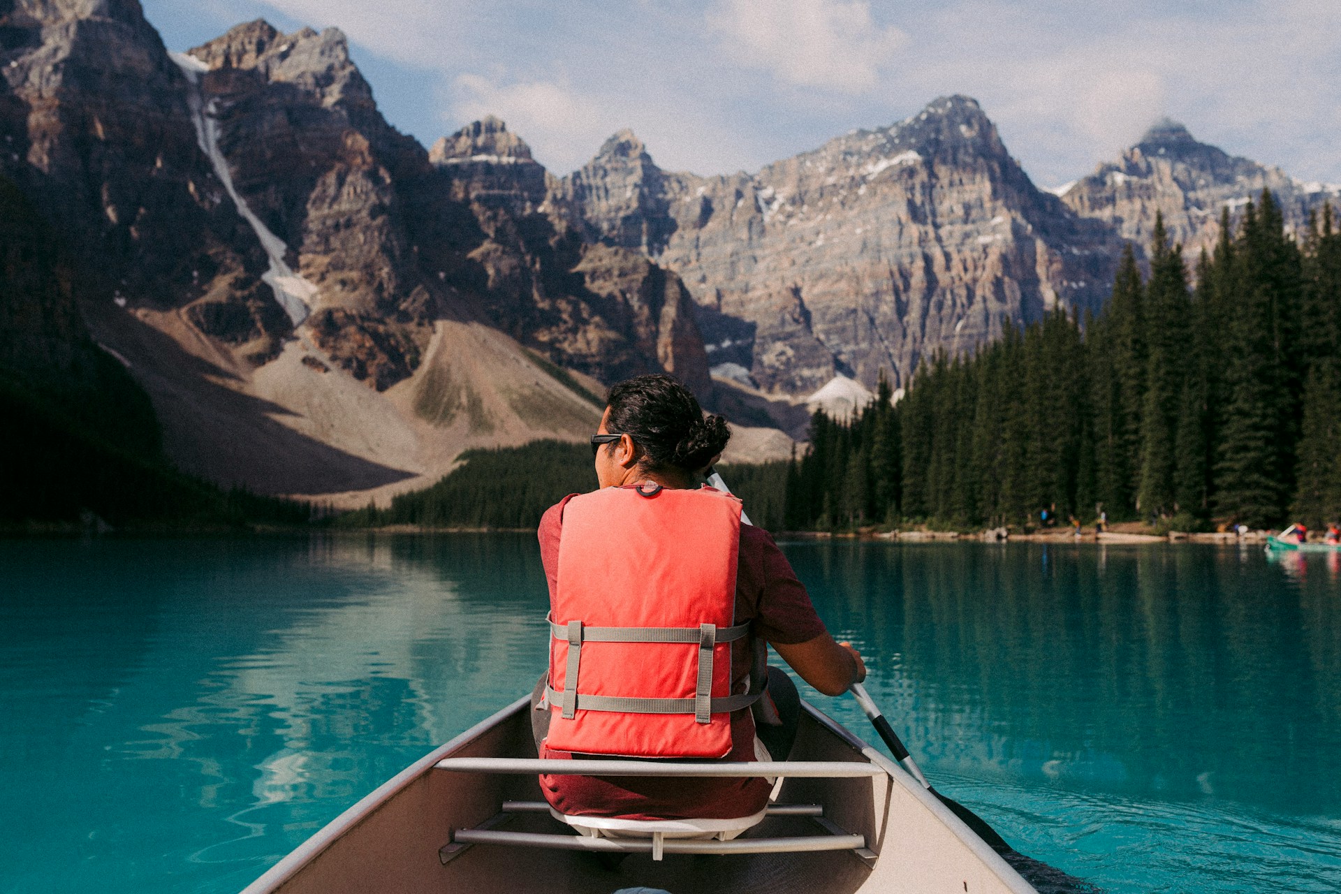 a canoeist on a mountain lake wearing a life jacket