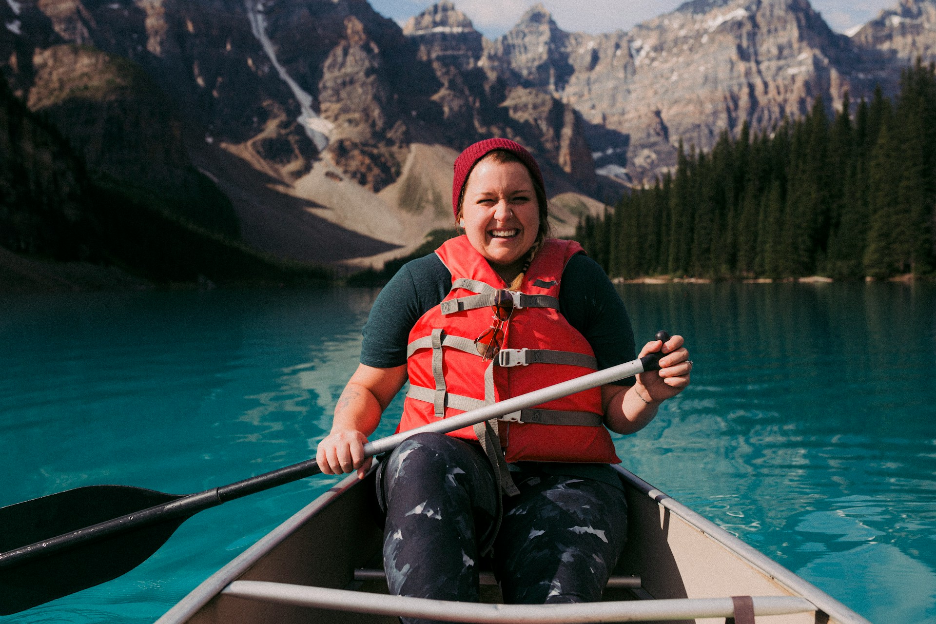 smiling woman in a canoe wearing a life jacket