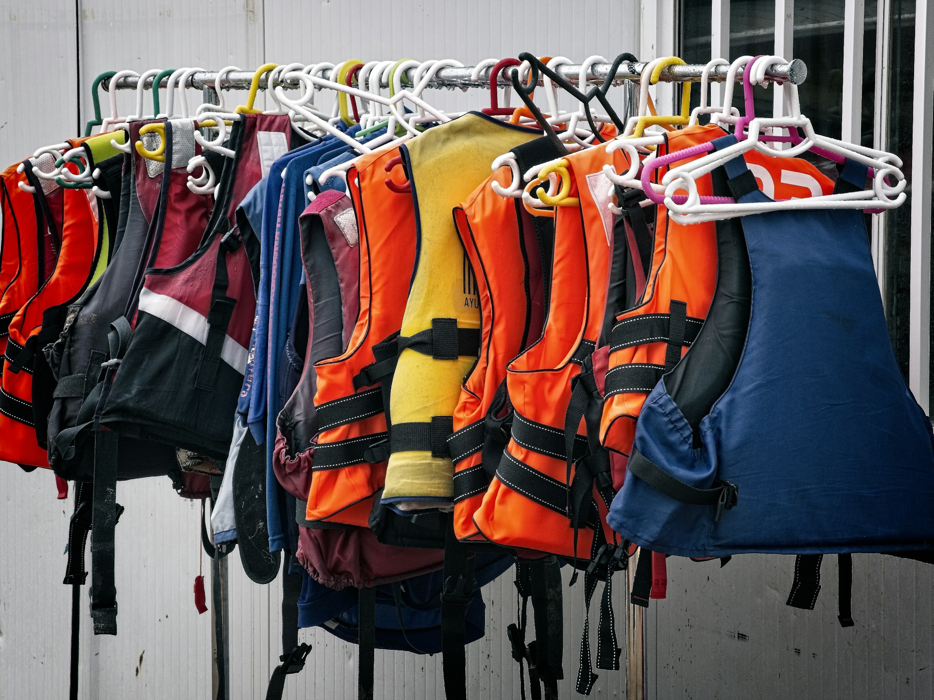 life jackets hanging on a rail