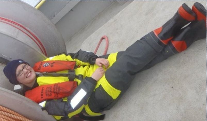 crew member sitting on the deck while taking time out from her seafarer job