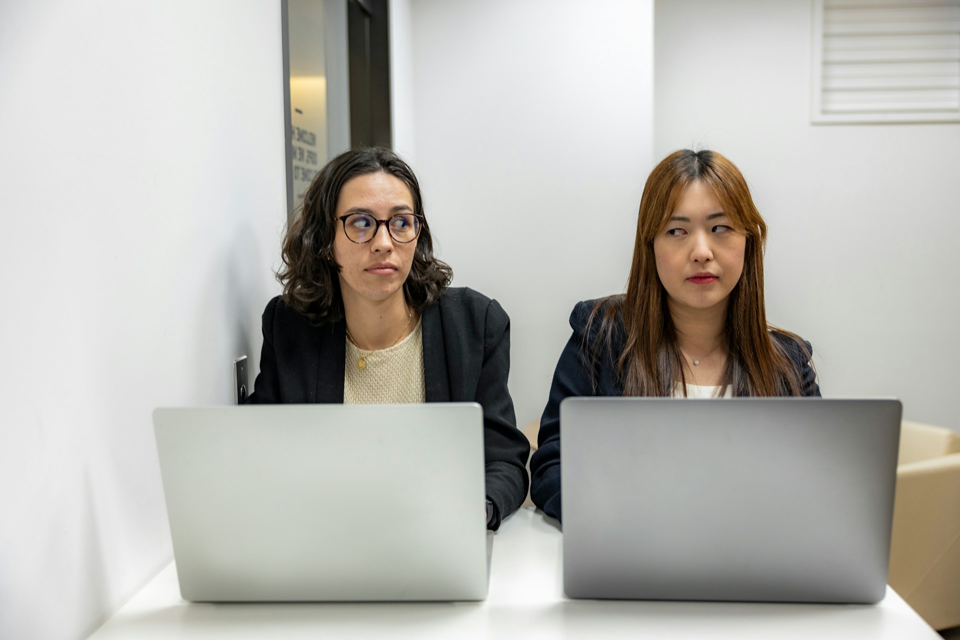 two office coworkers giving each other the side eye 